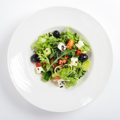 Fresh Greek salad in a bowl, top view