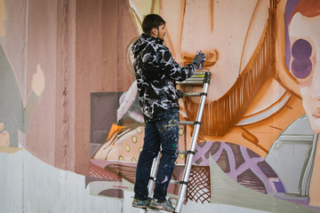 Graffiti artist painting on the wall