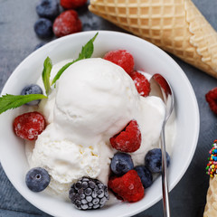 Vanilla ice cream scoops with fresh berries, closeup
