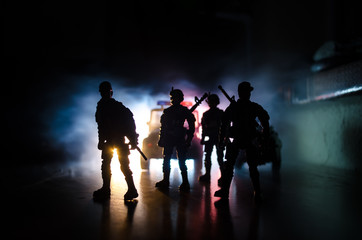 Anti-riot police give signal to be ready. Government power concept. Police in action. Smoke on a dark background with lights. Blue red flashing sirens. Dictatorship power.