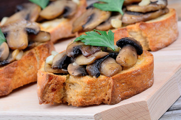 Mushroom bruschetta on chopping wooden board
