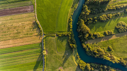River bend surrounded by fields from bird's eye view.