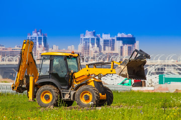 Tractor on the background of the city. Excavation.