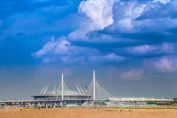 Clouds over the stadium. The building of the stadium in the background of the bridge.