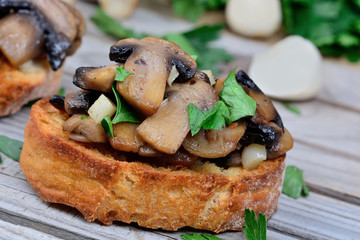 Mushroom bruschetta on wooden table
