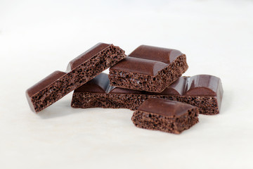 Pieces of porous chocolate on a white background