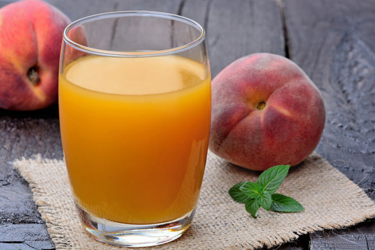 Peach juice in a glass on wooden table