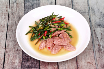 Fried Chinese chives with Thai sour sausage .
