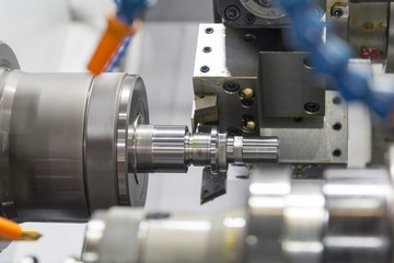 CNC lathe machine (Turning machine)  cutting the aluminium screw thread shaft.Hi-precision CNC machining concept.