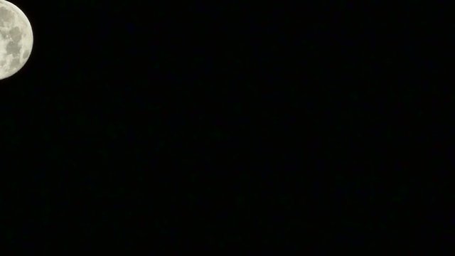 Full Moon Down. Time lapse of full moon falling on dark night sky. Timelapse, 30 second, 30fps HD video. Moon appears high in the east at night.