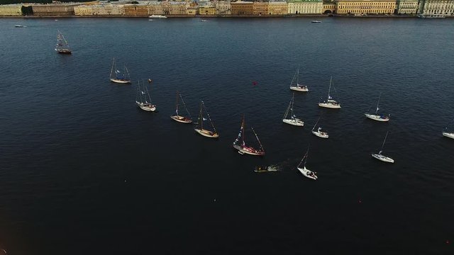 Aerial video of bay with floating sailing yacht fleet in marina during yachting regatta race shot from drone