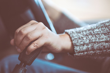 Woman hand shifting the gear stick while driving a car in vintage color tone