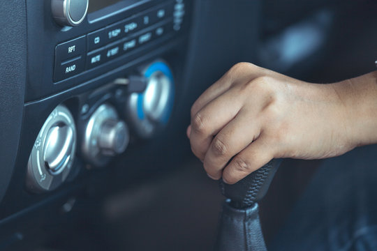 Woman hand shifting the gear stick while driving a car in vintage color tone