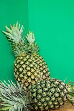 Fresh Tropical pineapples on green background 