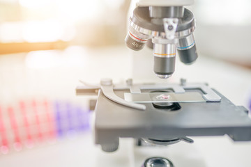 Microscope on the table in laboratory room with laboratory equipment