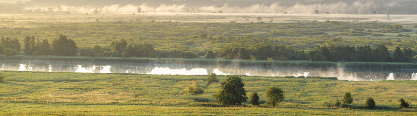 Foggy summer morning over the valley, fog and rising sun