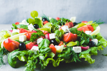 Fresh lettuce, tomatoes, olives and feta cheese in a bowl