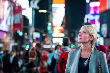 Fototapeta premium Kobieta pod wrażeniem na środku Times Square w nocy,