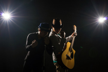 Musician Duo band hand holding the microphone and singing a song and playing the guitar on black...