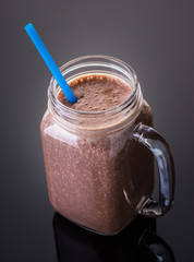 Milkshake chocolate in jar with a straw