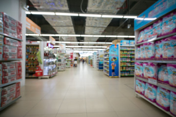 Supermarket blurred background with colorful shelves and unrecognizable customers