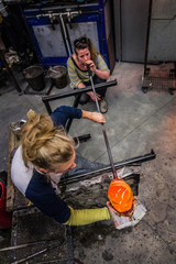 Two Women Shaping Blown Glass on the Blowpipe