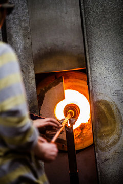 Glassmaker Flashing Piece of Glass in the Kiln