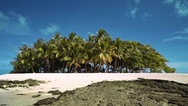 Small tropical island with palm trees, white sand and some rocks - Guyam Island, Philippines