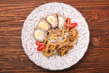 Boiled eggs in a layer of sausage meat wrapped with pasta