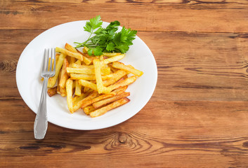 French fries and parsley on white dish and fork