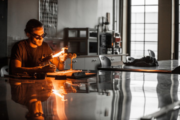 Glassblowing Young Man Working on a Torch Flame with Glass Tubes