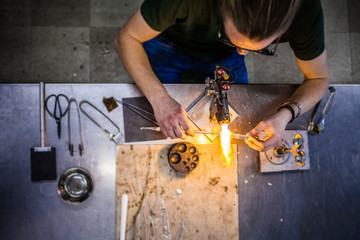 Glassblowing Young Man Working on a Torch Flame with Glass Tubes
