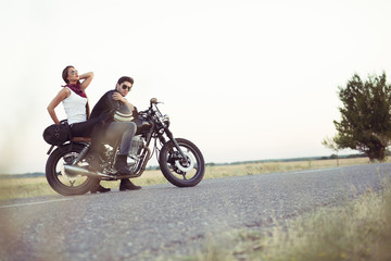 Sexy couple of bikers on the vintage custom motorcycle