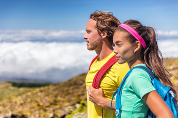 Couple hikers hiking in mountain nature landscape. Healthy active people lifestyle in summer outdoors backpacking with bags on trail walk.