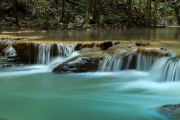 Small waterfall in the forest in summer.