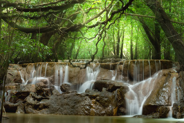 Small waterfall in the forest in summer.