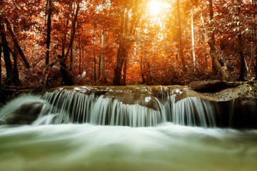Motion water at Small waterfall in the autumn forest.