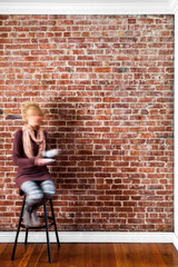 Fototapeta na wymiar Blurry Woman in front of a Flat brick Wall Perspective