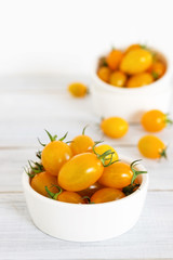 yellow cherry tomatoes in white ceramic bowl