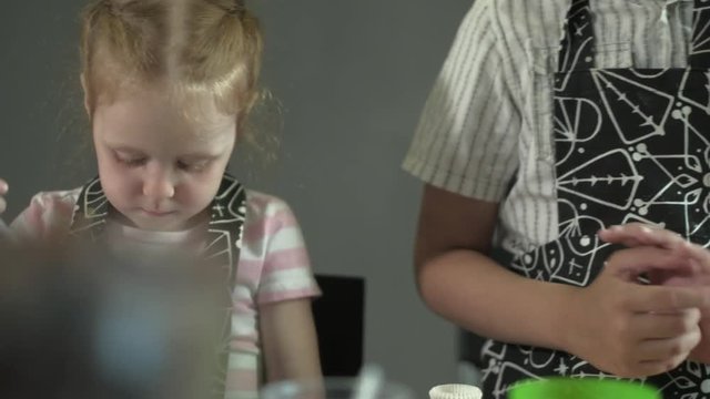 Close up portrait young baker examines and touching using finger chocolate 4k