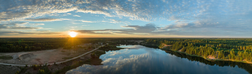Fototapeta na wymiar Beautiful sunset over the lake in summer forest. Aerial photography. Panorama.