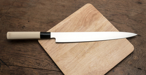 stainless steel kitchen Knife on wooden plate on wooden table from top view