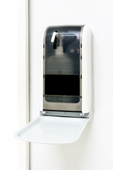 Automatic hand sanitizer dispenser on white wall