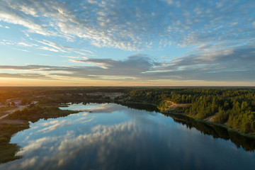Beautiful sunset over the lake in summer forest. Aerial photography.