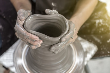 Hands working on pottery wheel