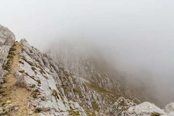 Dramatic scenery in Piatra Craiului Mountains, Romania, with beautiful mist clouds and limestone peaks