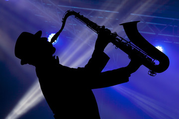 Man playing on saxophone against the background of beautiful light