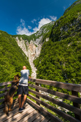 Fototapeta na wymiar Man and dog looking at Boka waterfall in Slovenia
