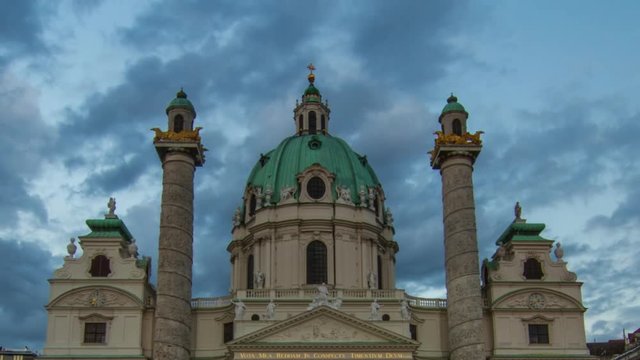 Timelapse of Karlskirche (Church) at Karlsplatz in Vienna/Austria first district (old town) with reflection in the fountain in front of the picture; Sunset with beautiful moving clouds and light.
