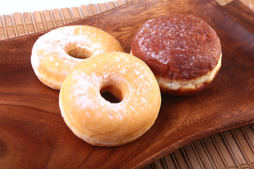 Assorted Homemade Doughnuts with Jelly filled and powdered sugar on wooden salver. Selective focus.